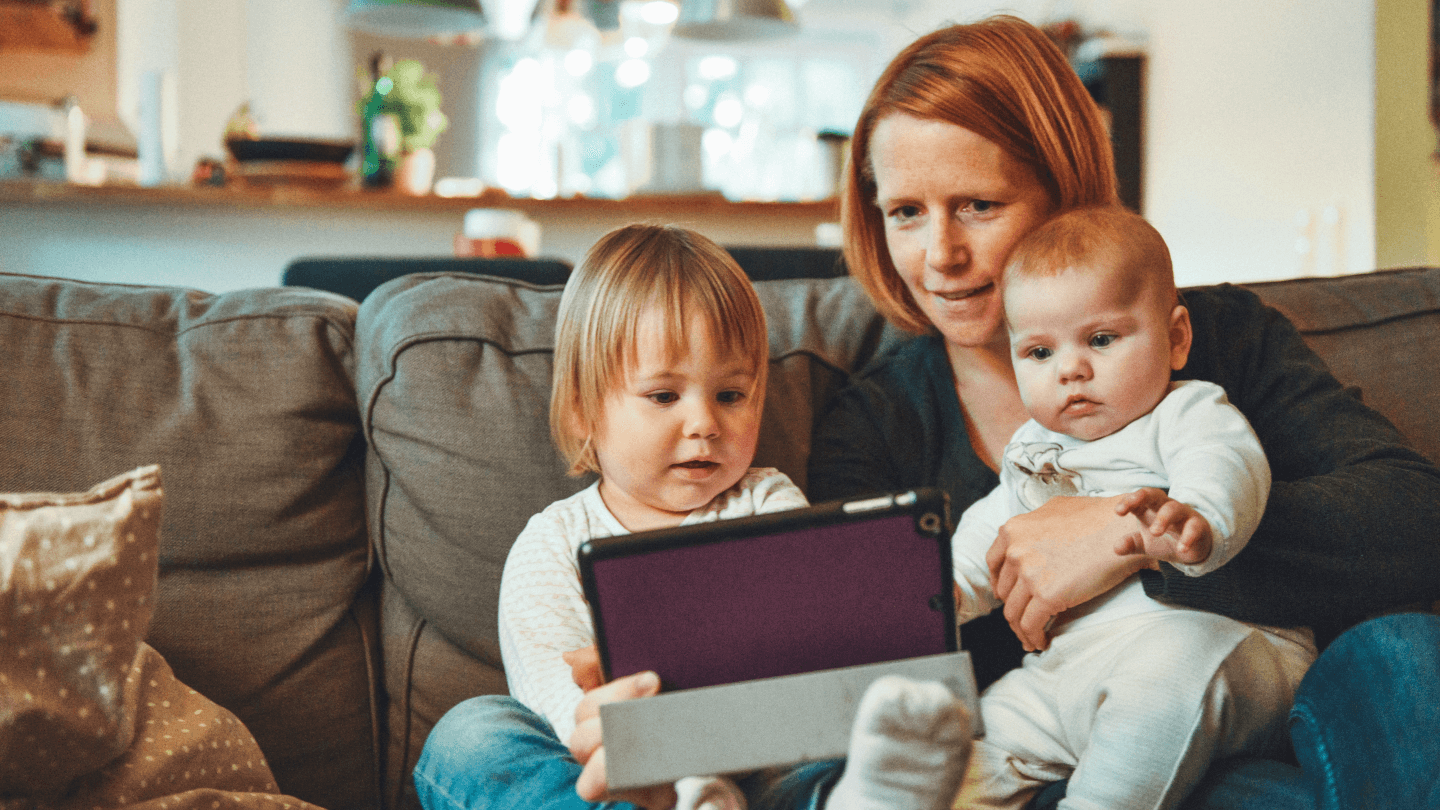 woman using a tablet with 2 children