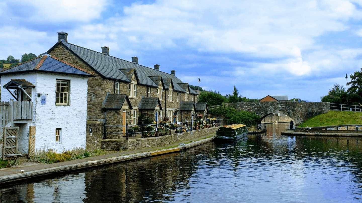 houses next to a canal with a canal boat moored up