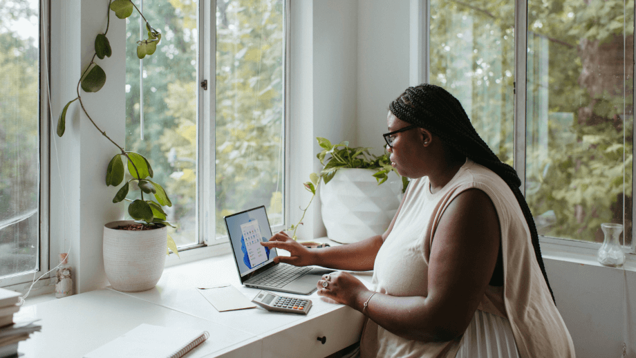 woman on laptop next to window