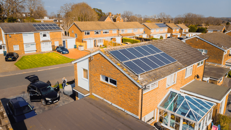 a street of houses with the closest one having solar panels on them