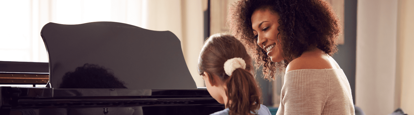 teacher and student playing the piano