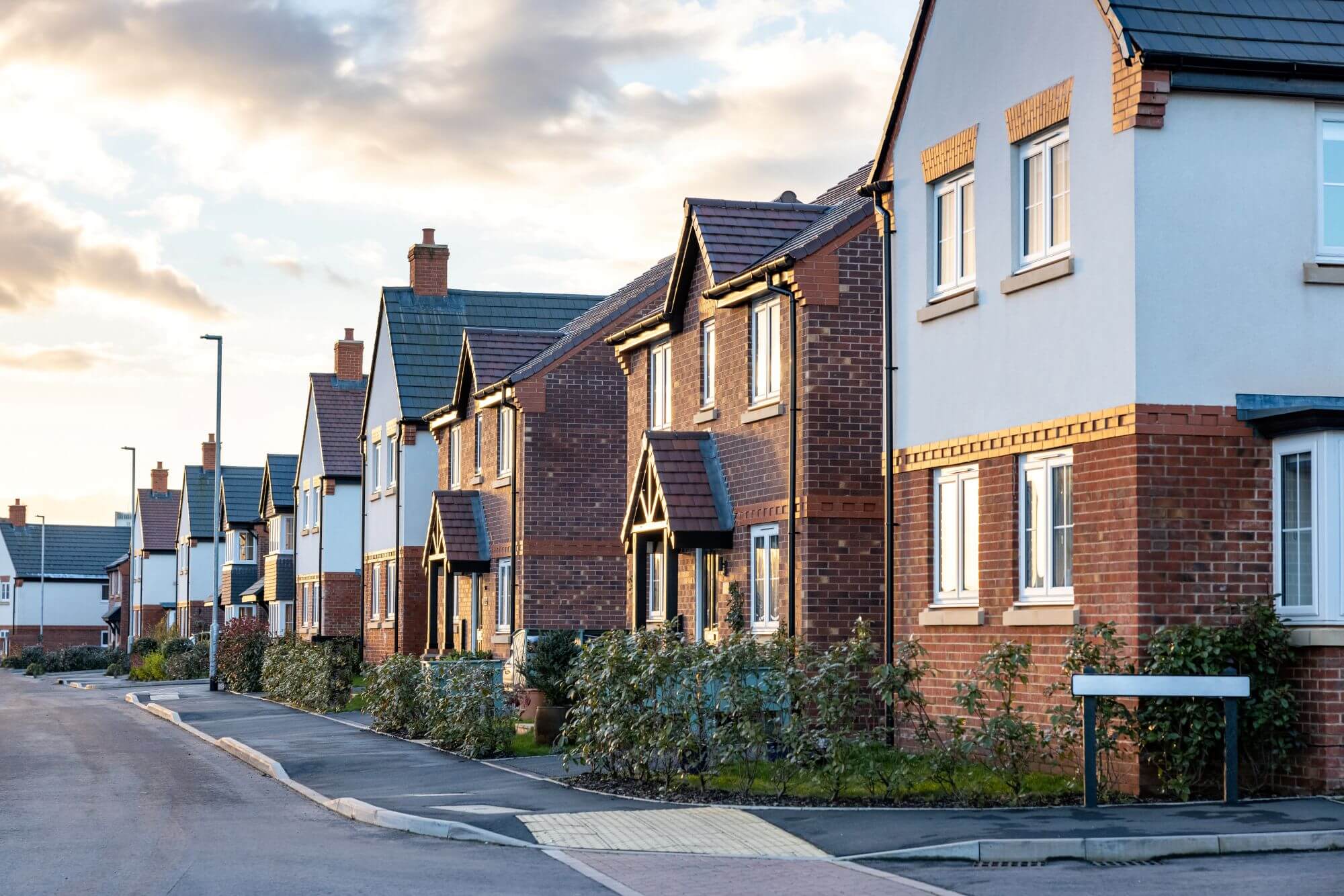 A typical residential street in England, with cloudy skies in the background